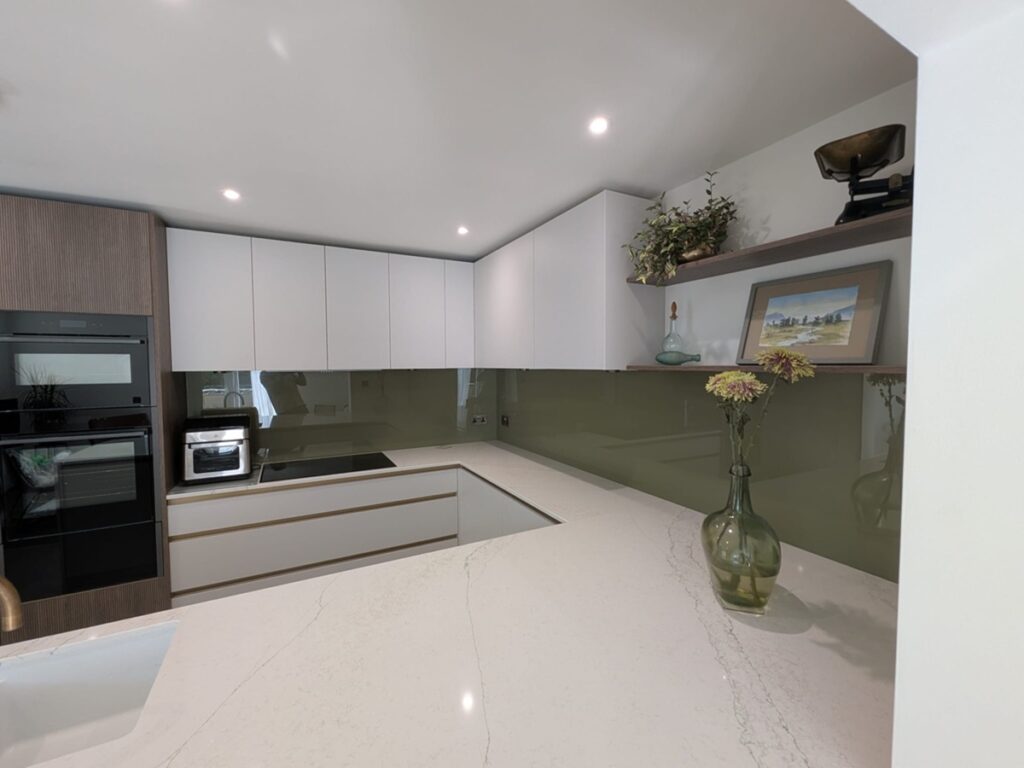 modern handleless, white kitchen with green glass splashbacks in Milford-on-sea